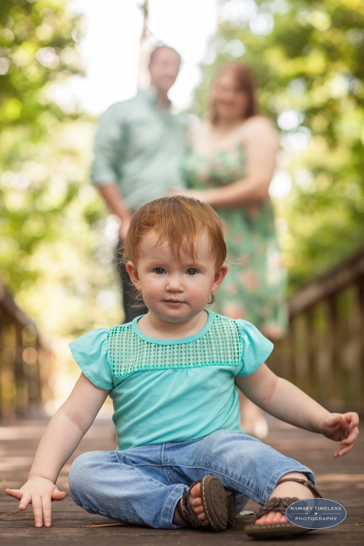 A little one on the bridge, family soft behind